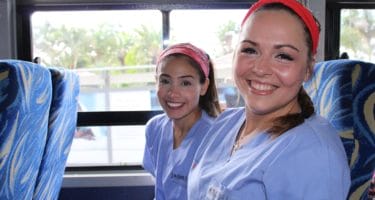 Two IMR volunteers traveling to clinic on a bus in Zambia | Short-term medical mission missions for undergraduate students from IMR offer the opportunity to participate in patient care in a clinic setting