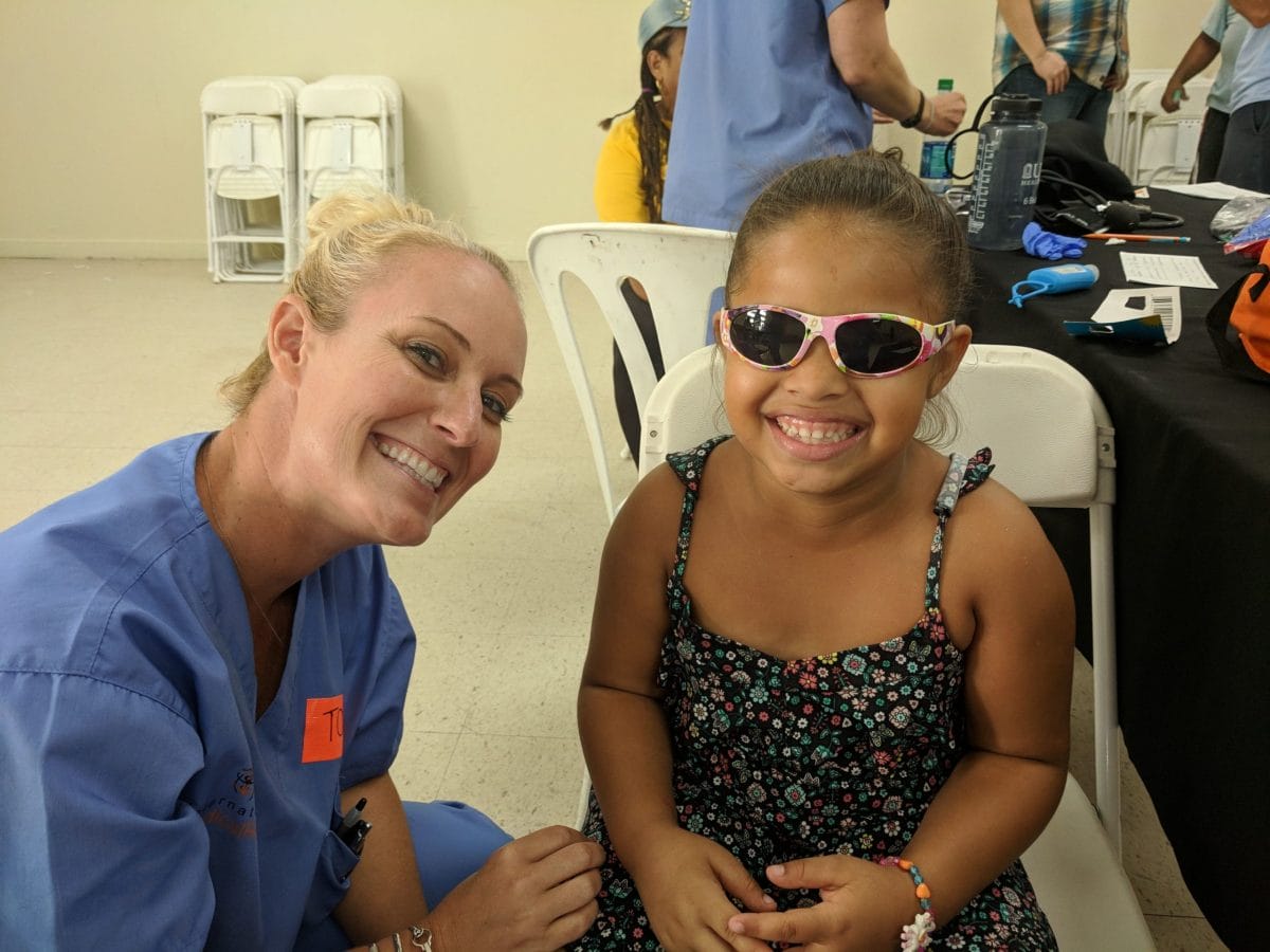 Puerto Rico clinic - volunteer with young girl in sunglasses