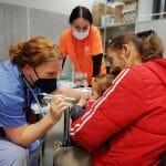 IMR volunteer examining Ukrainian patients in clinic in Poland