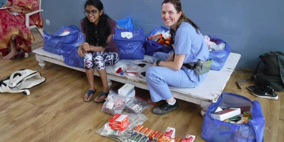 Photo of a female IMR volunteer with a patient | Short-term medical mission missions for graduate students from IMR offer the opportunity to participate in patient care in a clinic setting.